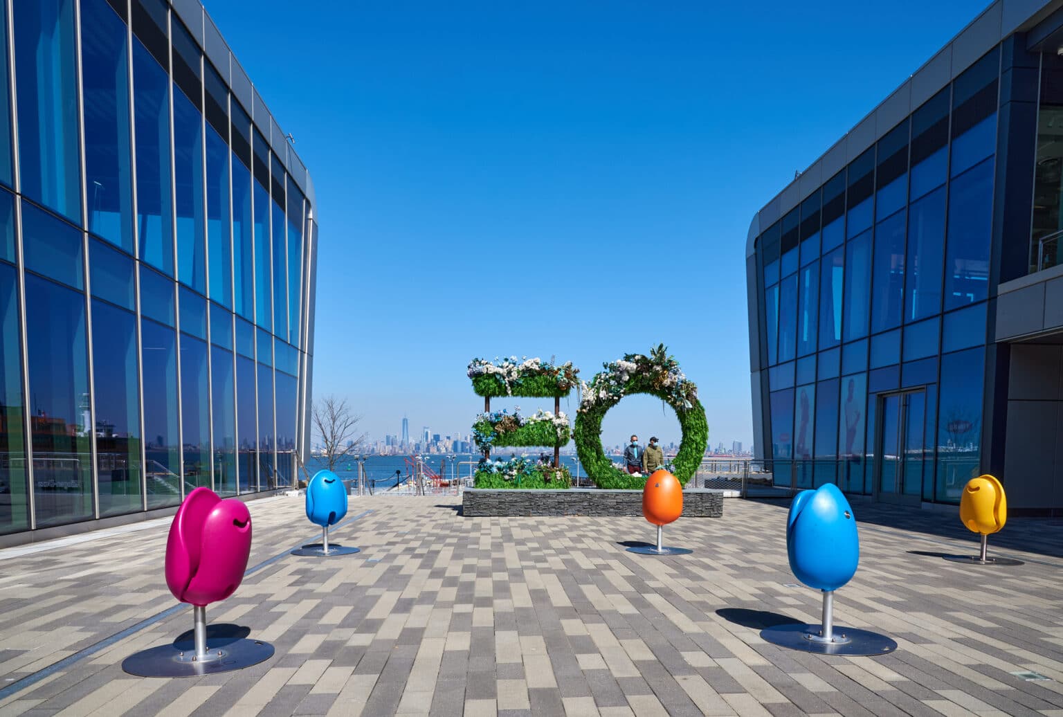 Staten Island, NY USA - March 21 2021: A plaza at Empire Outlets in St. George, Staten Island, NYC with a flower sculpture and colorful seats shaped like eggs. It is the first outlet mall in New York City, Designed by SHoP Architects and developed by BFC Partners.