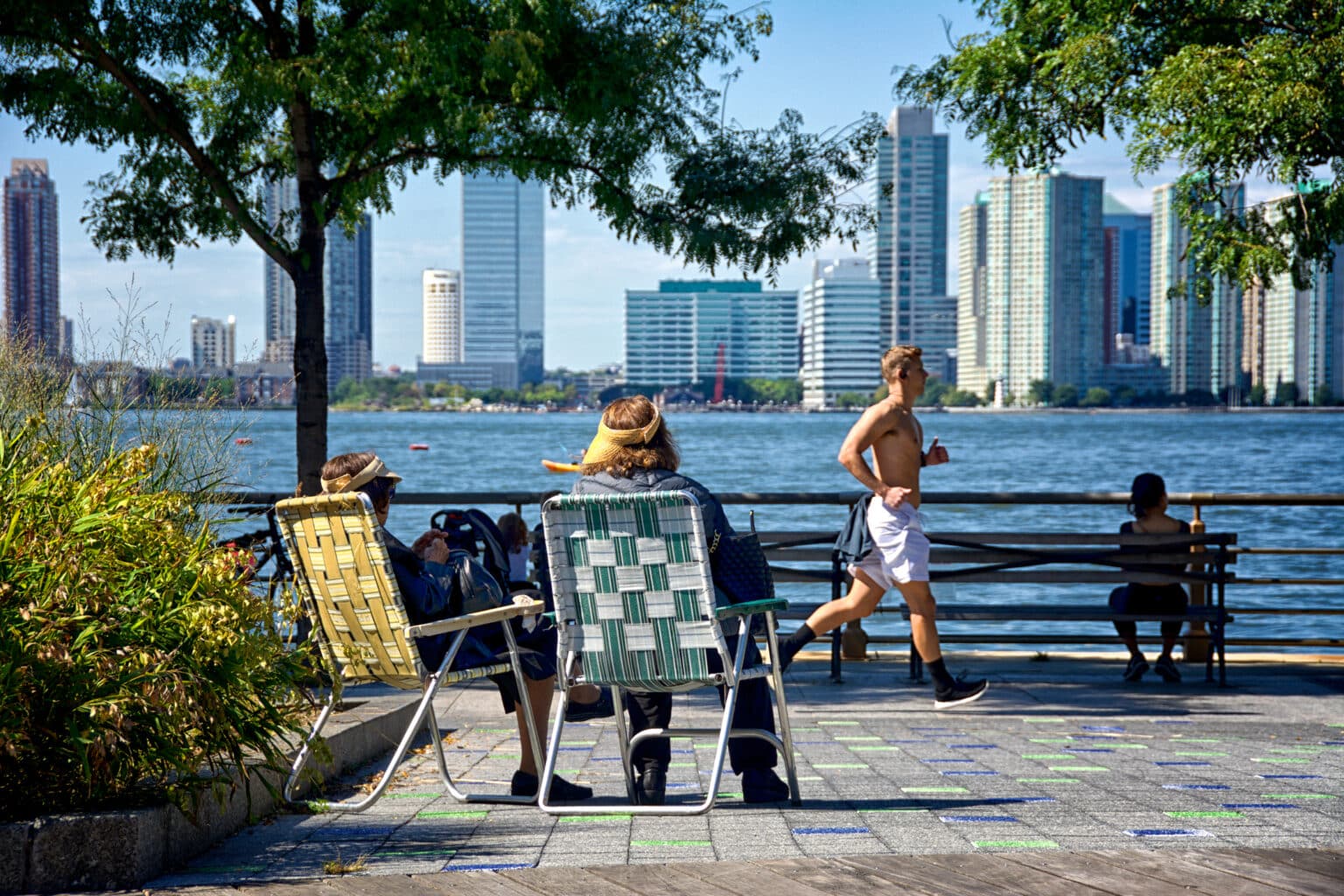 Women relaxing along Hudson River Park waterfront , Lower Manhattan, New York City, USA
