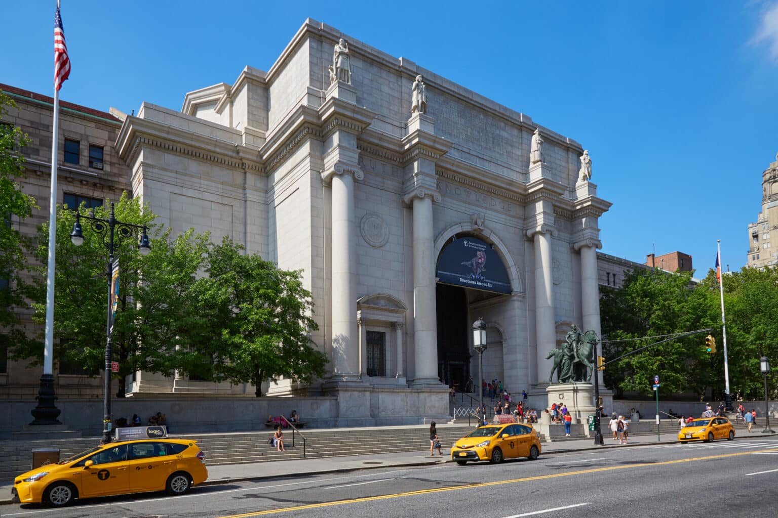 NEW YORK - SEPTEMBER 13: American Museum of Natural History building facade with people and yellow taxi in a sunny day, blue sky on September 13, 2016 in New York. This is one of the largest museum of natural history of the world.