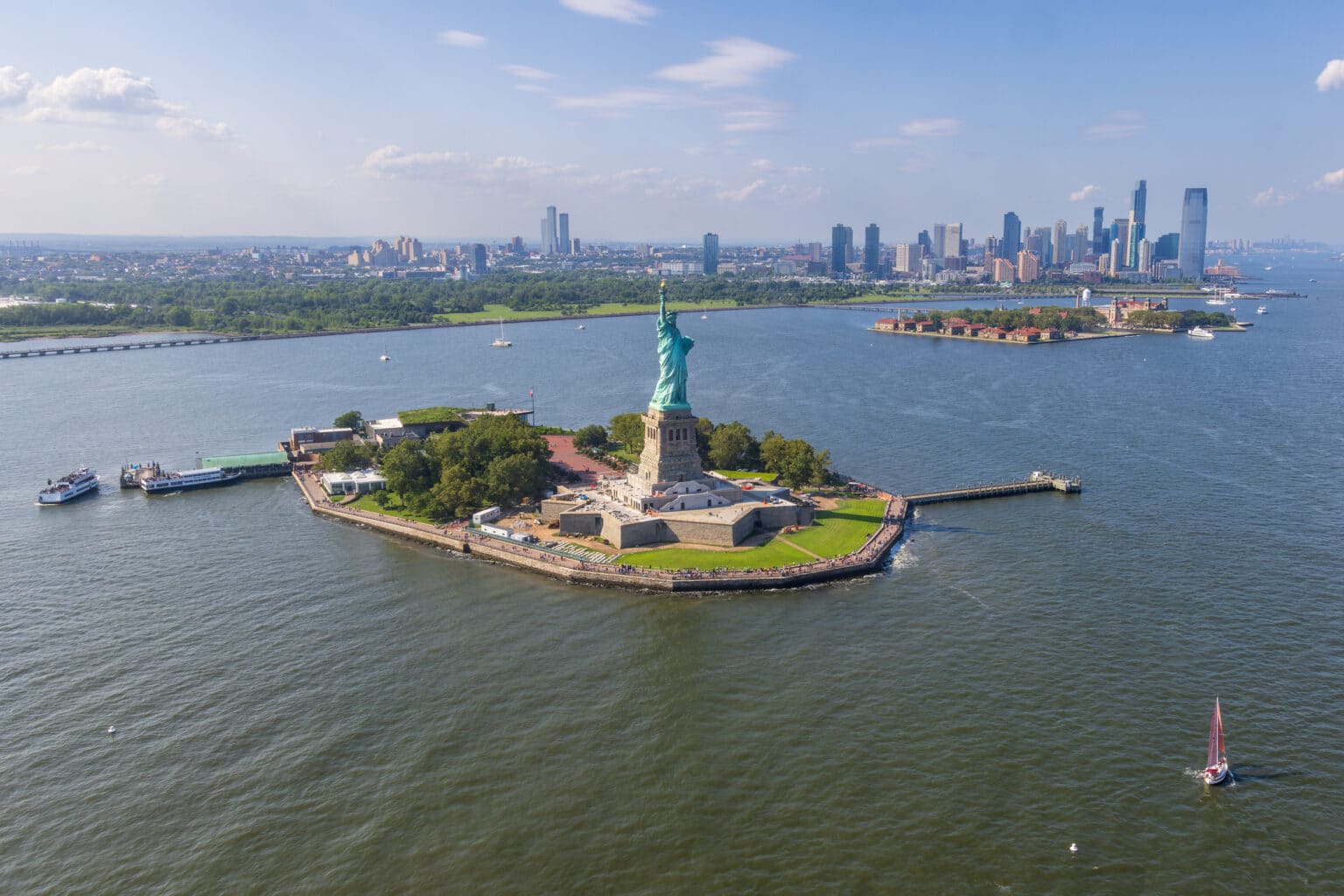 Aerial view of Liberty island and the Statue of Liberty with Jersey City in the background, New York City